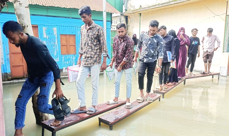 পরীক্ষাকেন্দ্রের ভেতরে পানি ঢুকেছে। পানিতে বেঞ্চ বসিয়ে শিক্ষার্থীরা প্রবেশ করছেন। আজ রোববার সকালে ইসলামপুর উপজেলার বিএম কলেজে